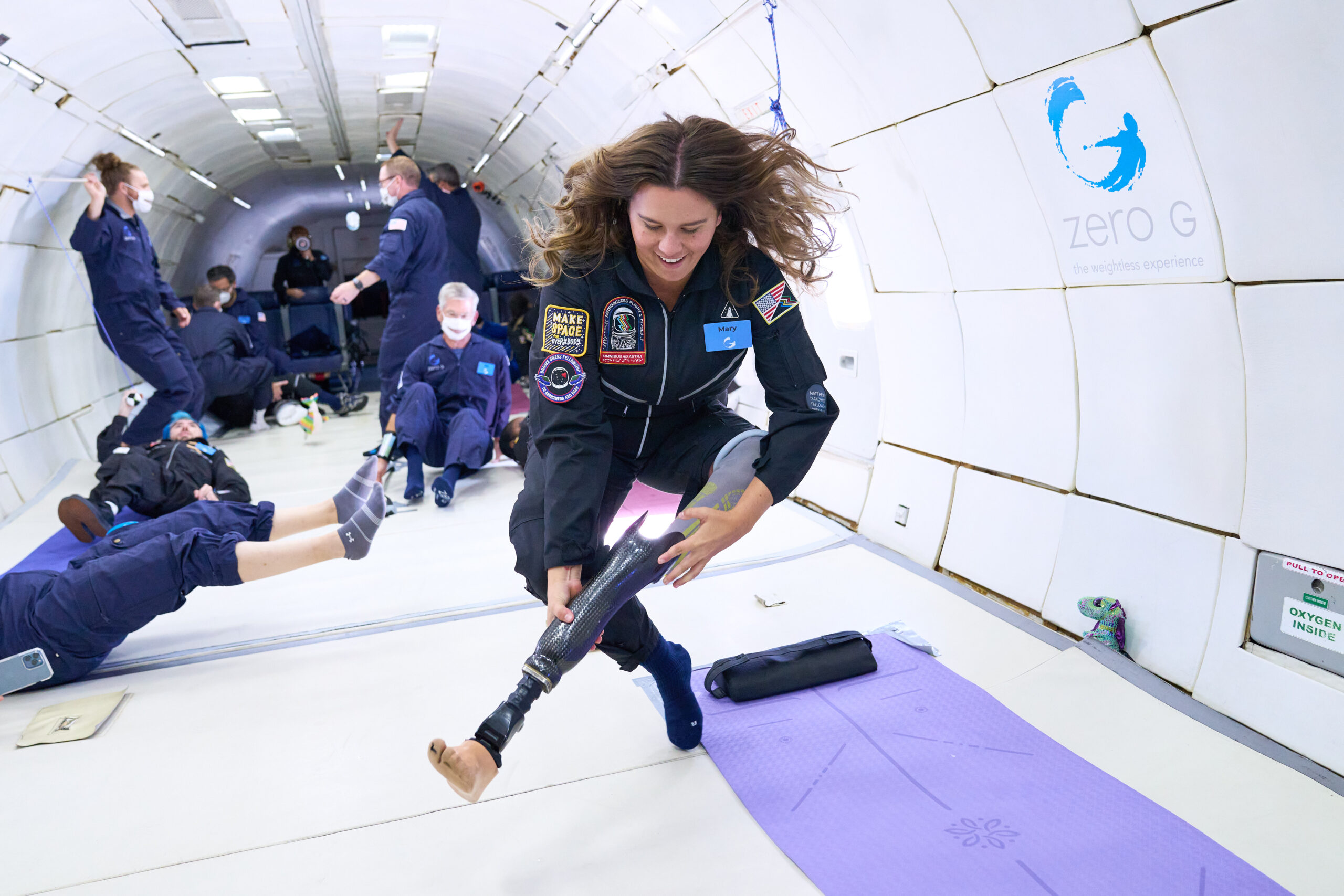 Large group of smiling students performs a research experiment while floating inside the ZERO-G plane. Credit: ZERO-G.